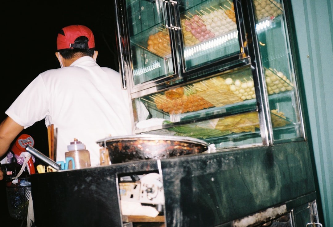 man in white shirt standing near food display counter