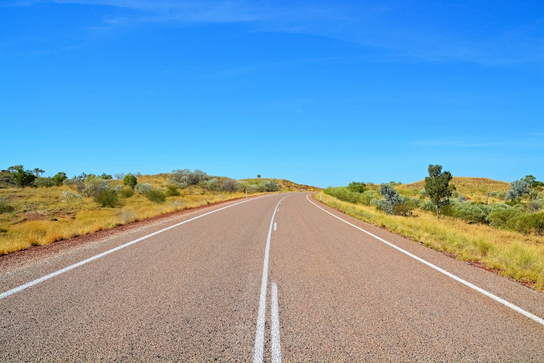 gray concrete road under blue sky during daytime