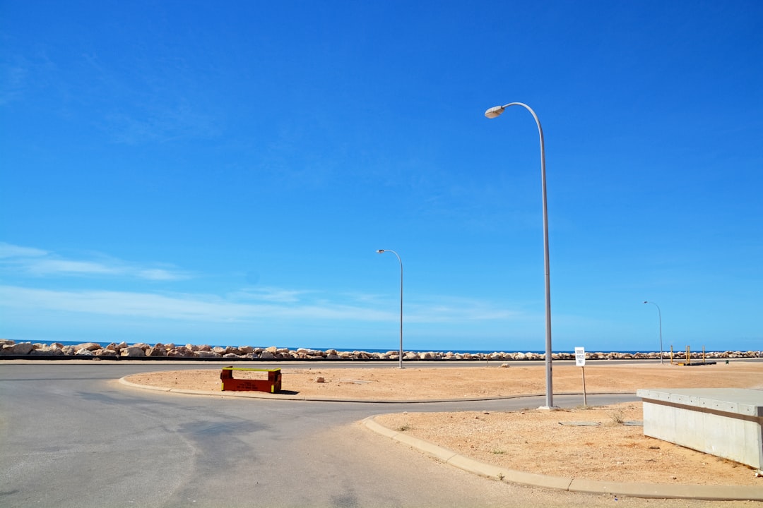 white street light on brown sand under blue sky during daytime