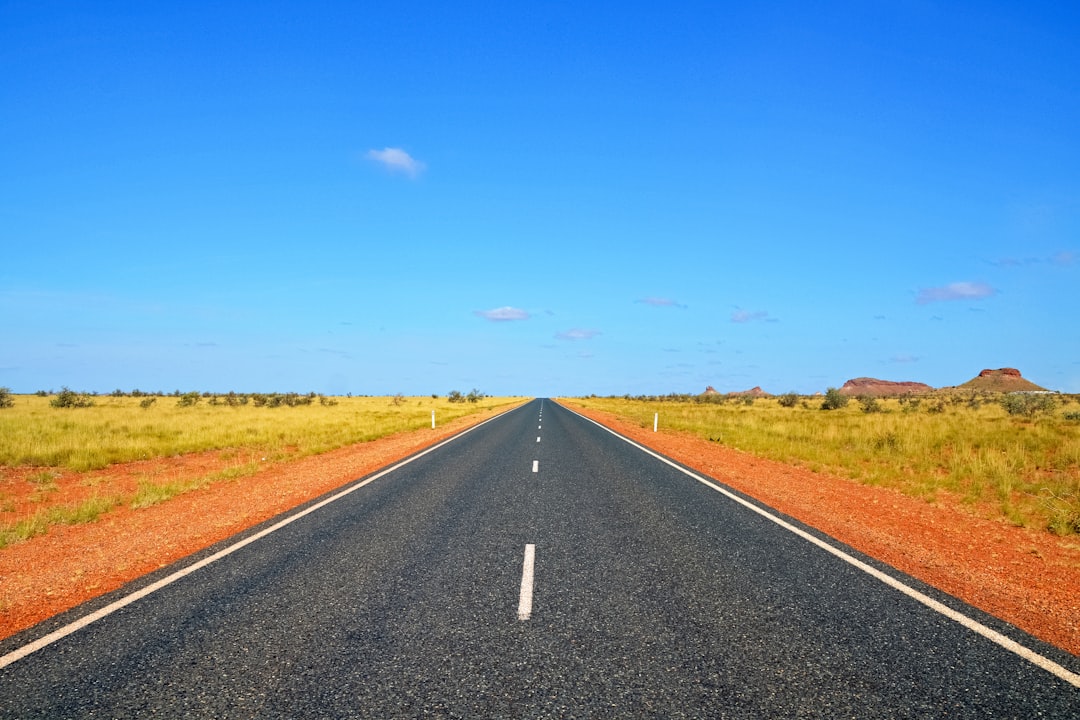 gray concrete road under blue sky during daytime