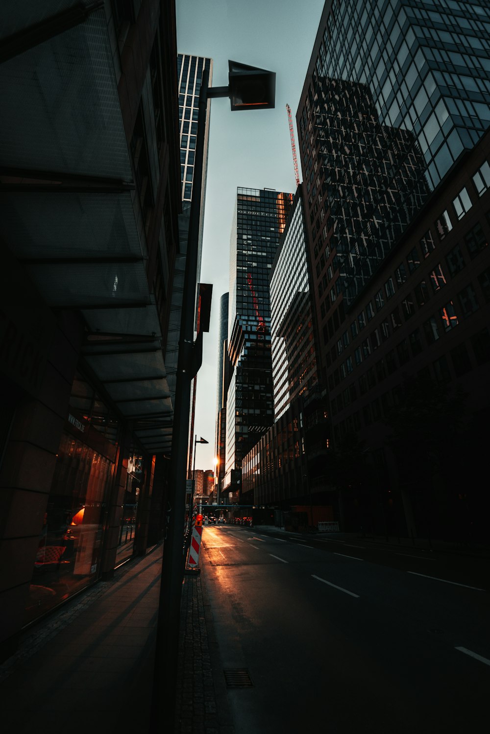 black asphalt road between high rise buildings during night time