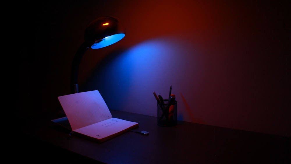 lámpara de mesa en blanco y negro encendida junto al papel blanco de la impresora sobre la mesa de madera marrón