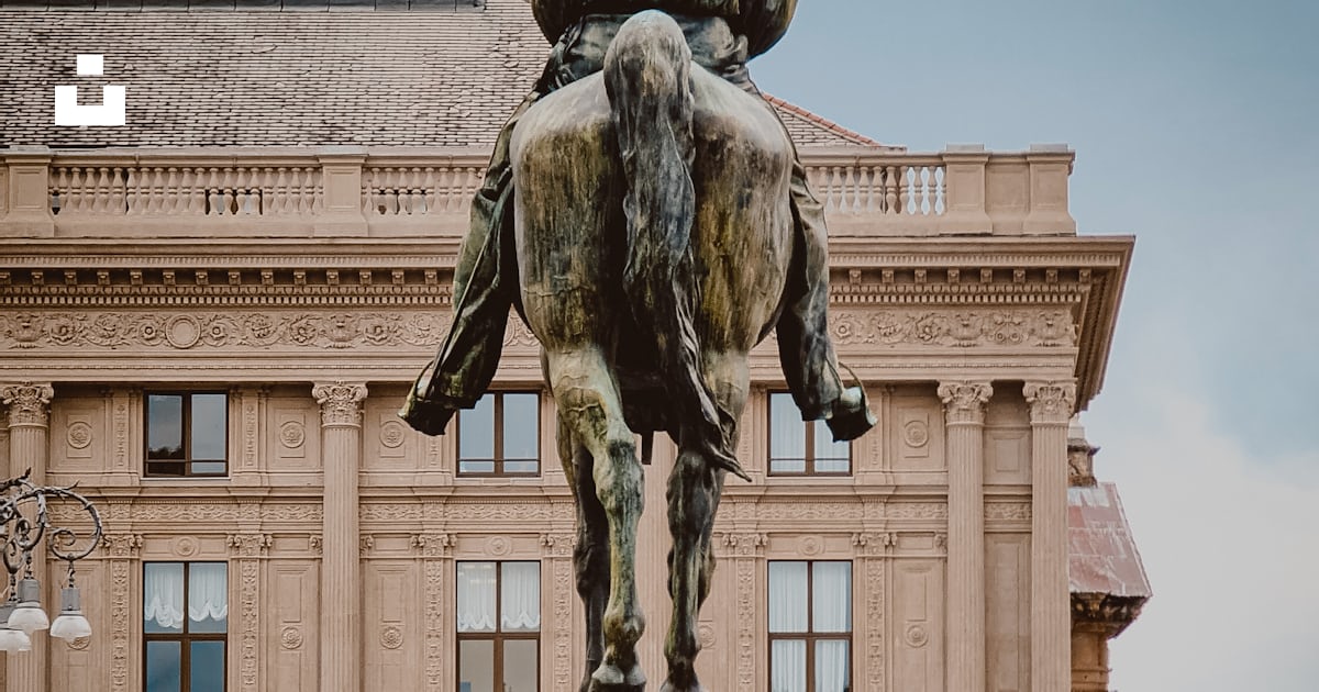 Man riding horse statue near beige concrete building during daytime ...