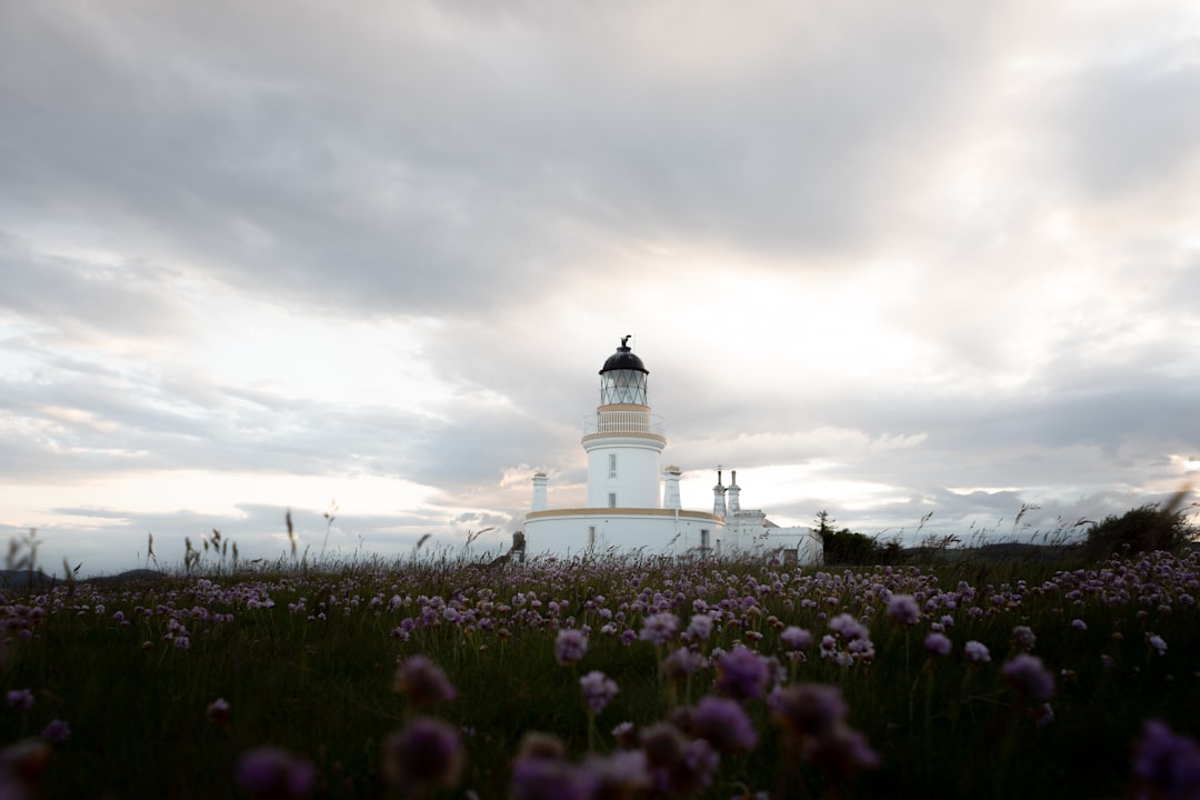 white lighthouse under cloudy sky during daytime