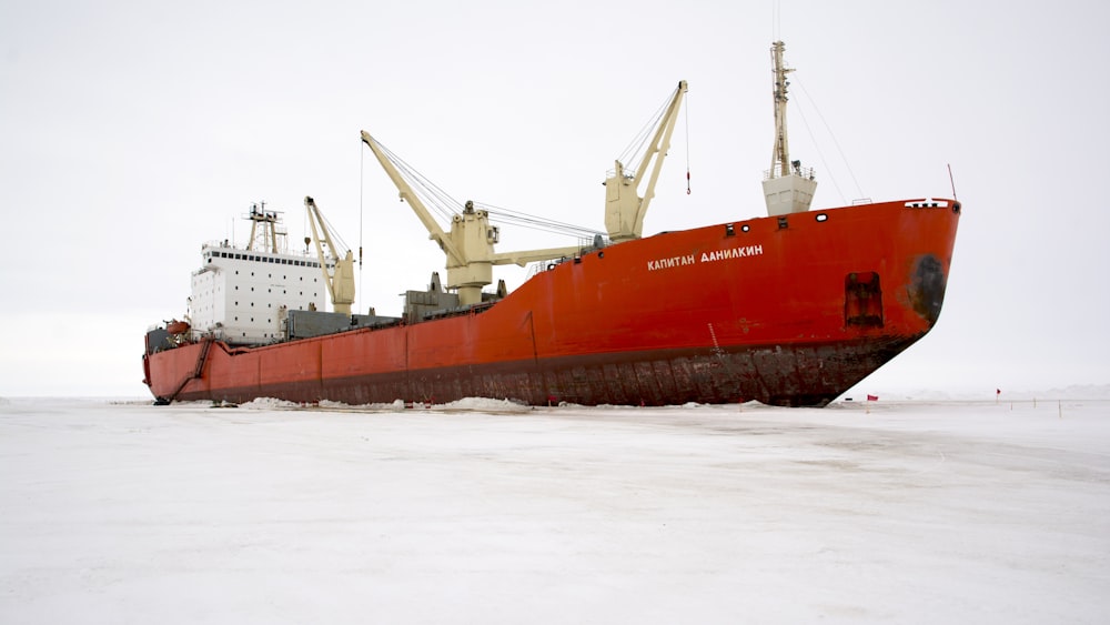 navio vermelho e branco no mar durante o dia