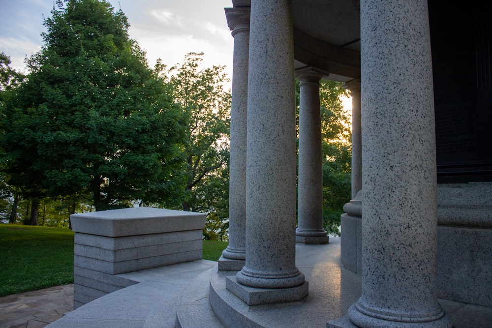 gray concrete pillar near green trees during daytime