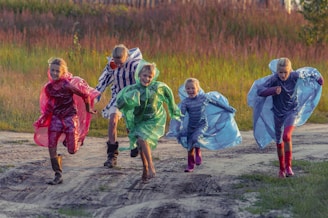 people in green and blue jacket walking on dirt road during daytime