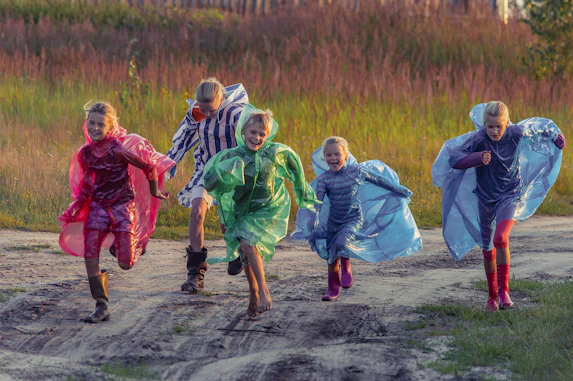 people in green and blue jacket walking on dirt road during daytime
