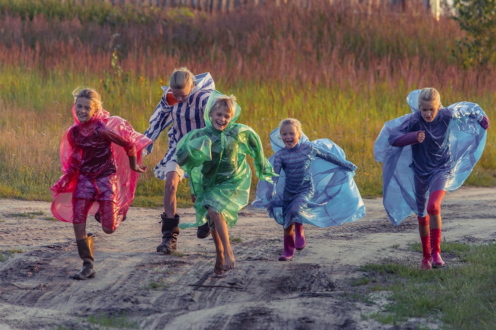 people in green and blue jacket walking on dirt road during daytime