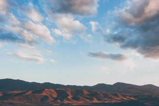 A serene landscape painting of rolling hills under a soft sky.