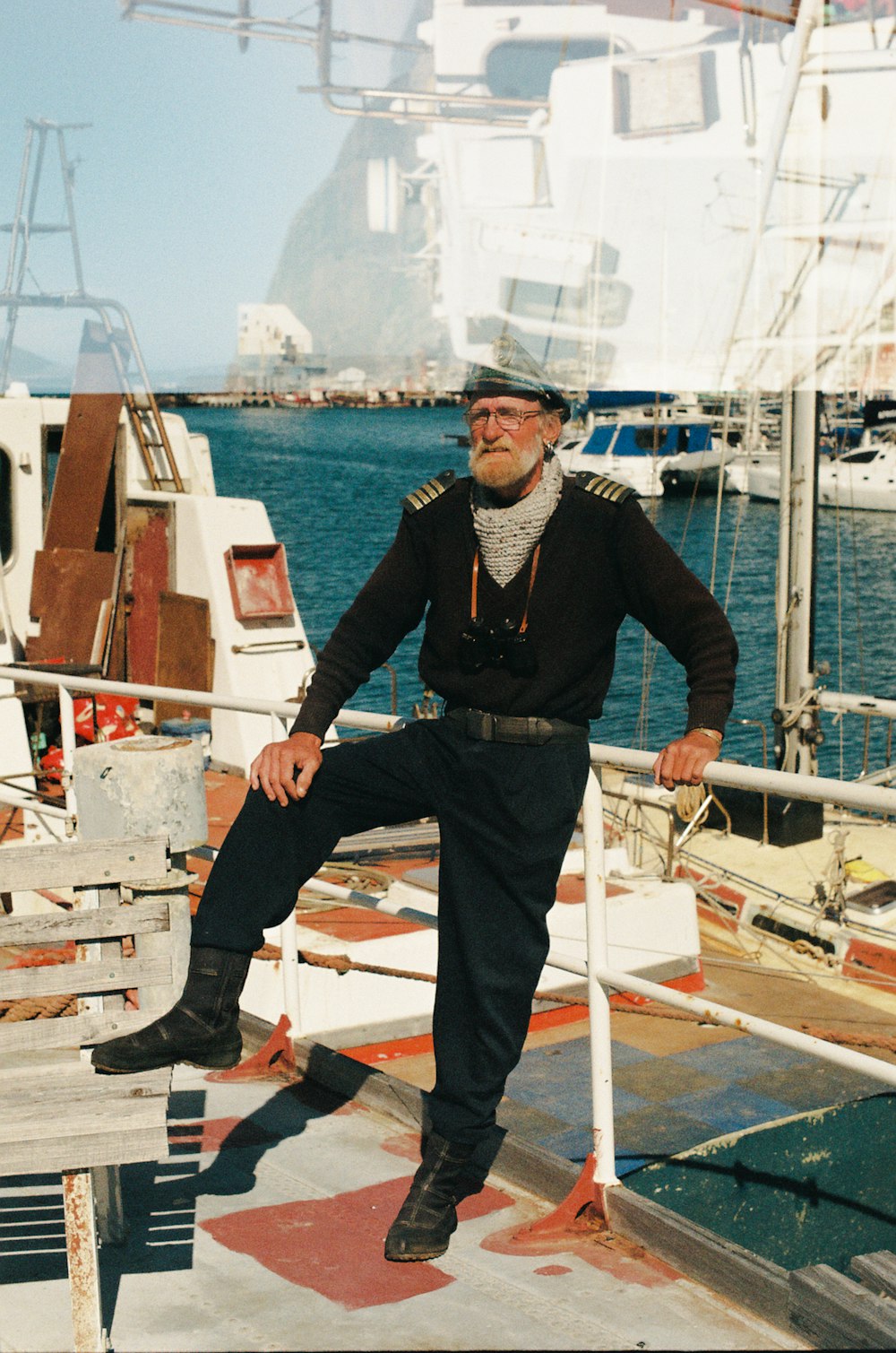 homme en veste noire et jean bleu debout sur un bateau blanc pendant la journée