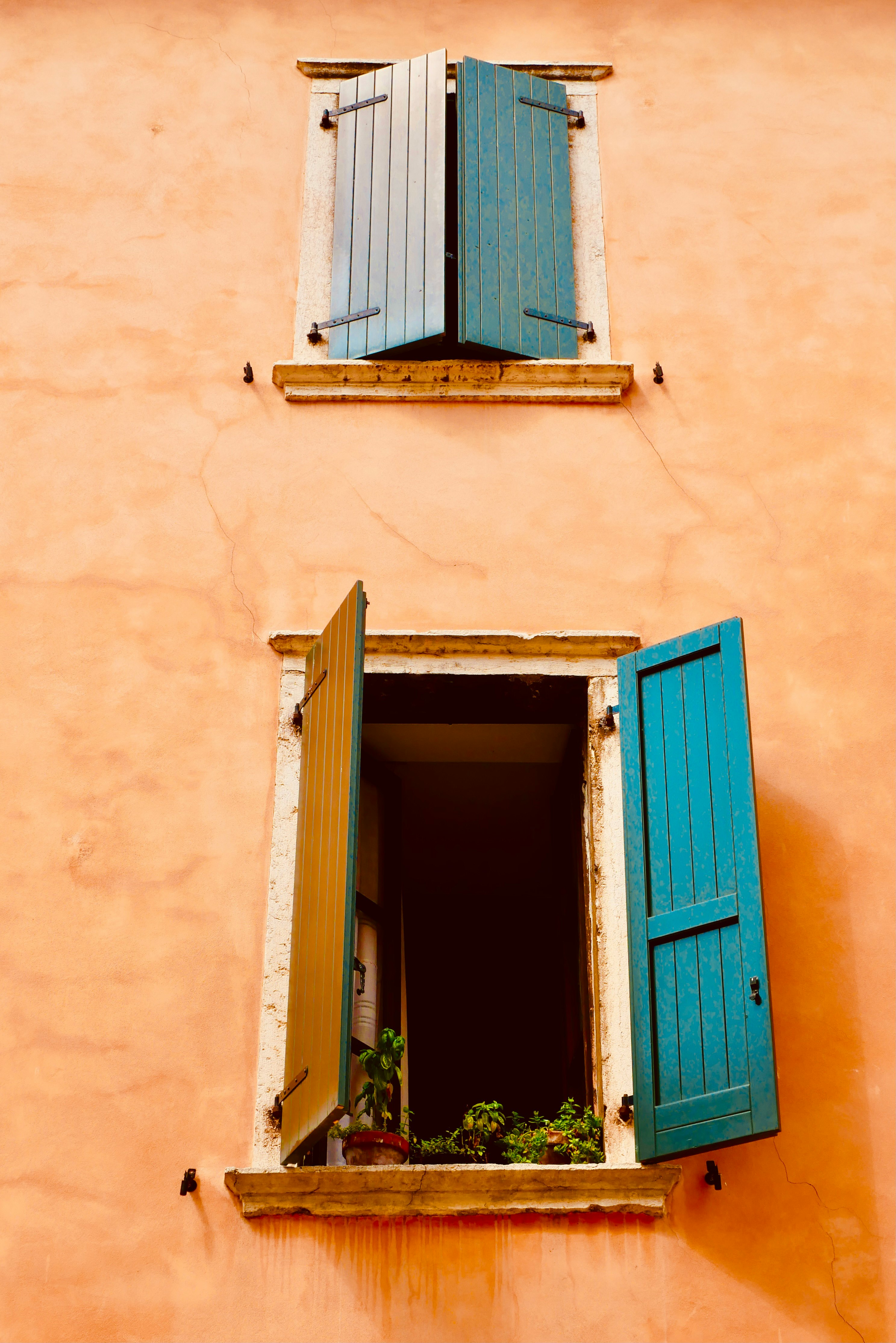 blue wooden window on brown concrete wall