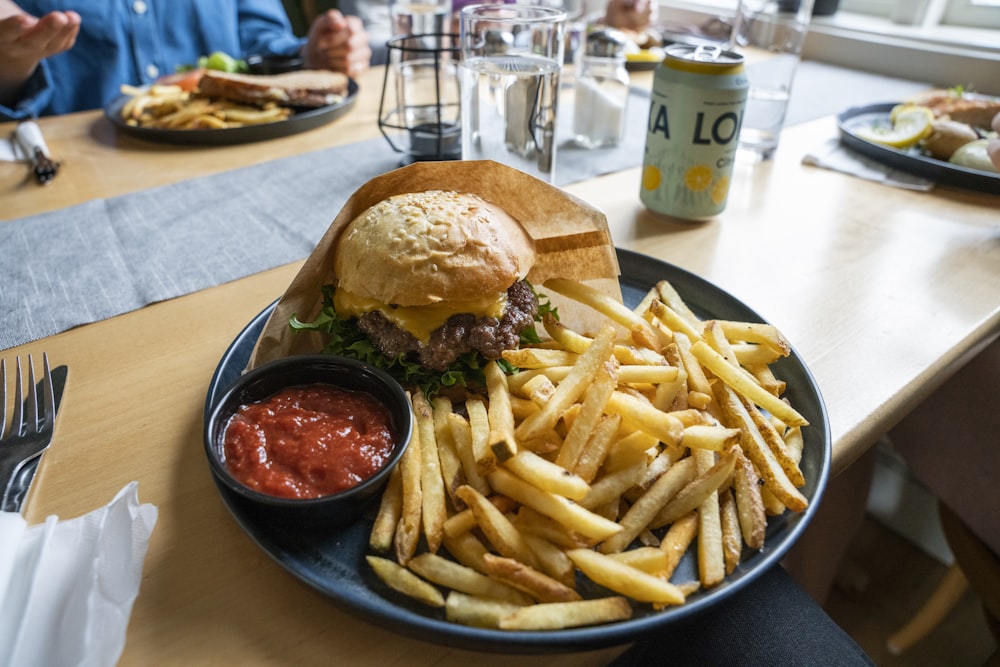 burger and fries on black plate