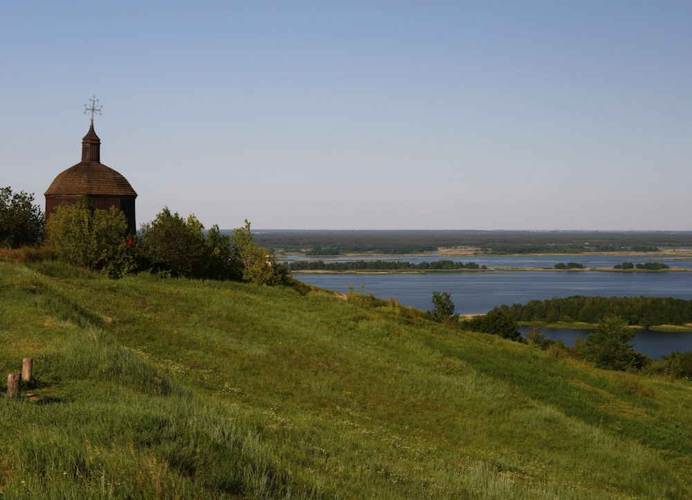 brown house on green grass field near body of water during daytime