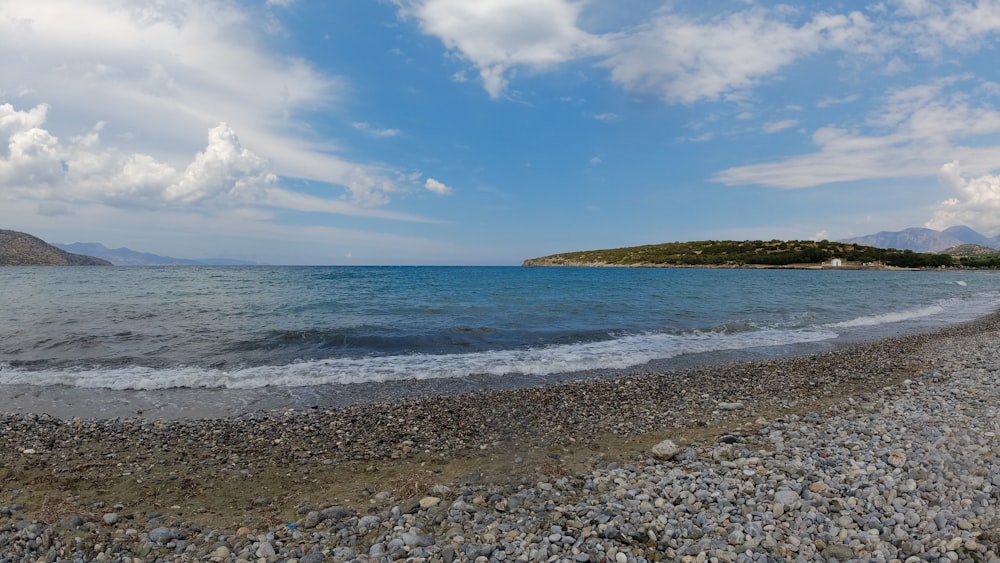 Mar azul bajo cielo azul y nubes blancas durante el día