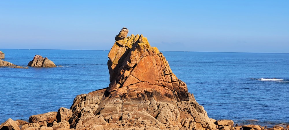 brown rock formation near body of water during daytime