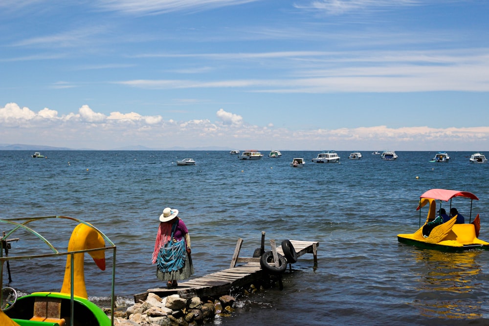 man in white shirt standing on sea dock during daytime