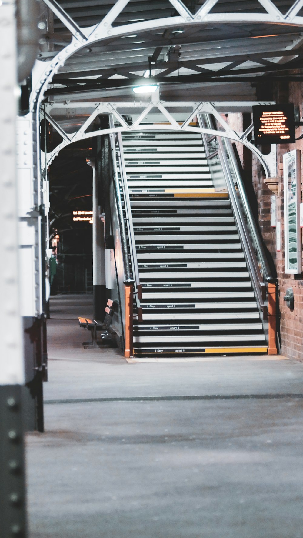 man in black jacket and black pants standing beside white and gray steel ladder during daytime