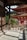 A traditional Japanese temple with wooden architecture is visible, featuring a large hanging bell and intricate red pagoda-style structures. Lush green vegetation surrounds the area, and sunlight casts shadows and contributes to the tranquil ambiance.