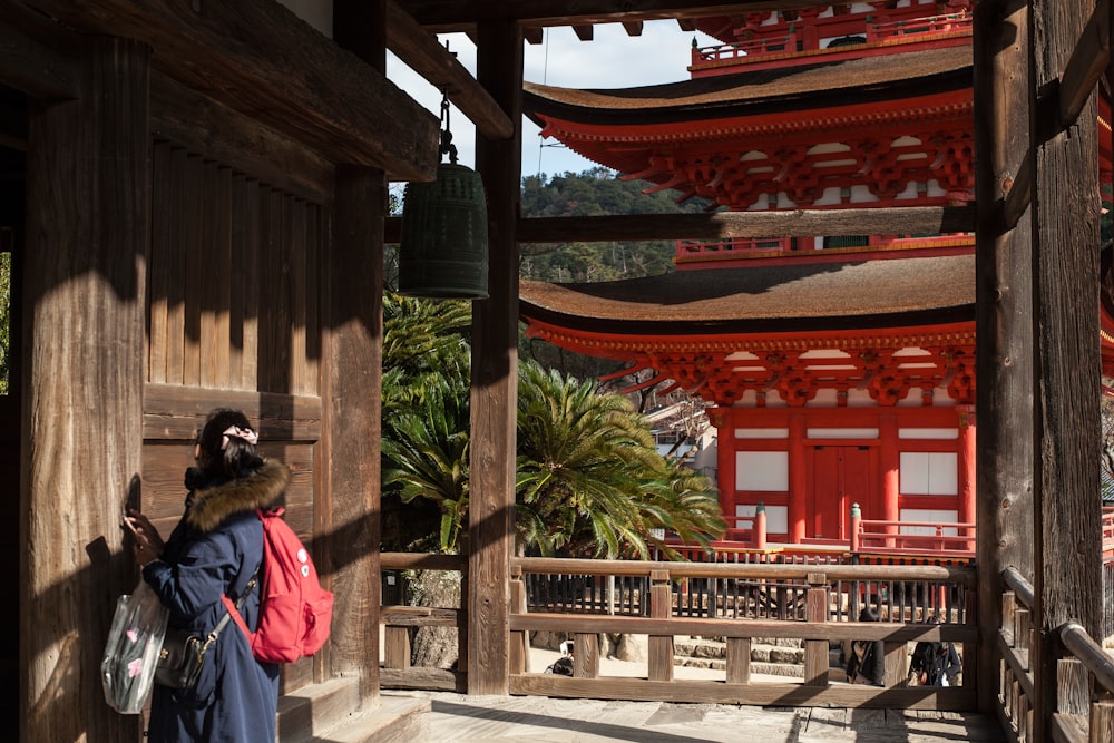 woman in blue and white dress standing near brown wooden gate during daytime