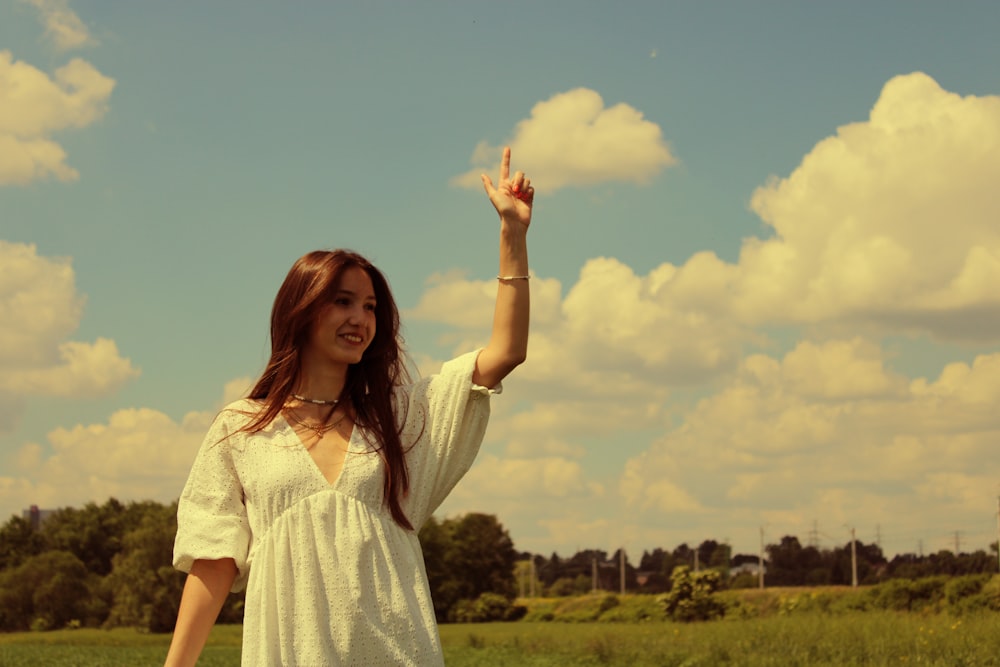 woman in white dress standing on green grass field during daytime