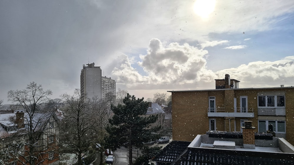 brown concrete building near green trees under white clouds during daytime