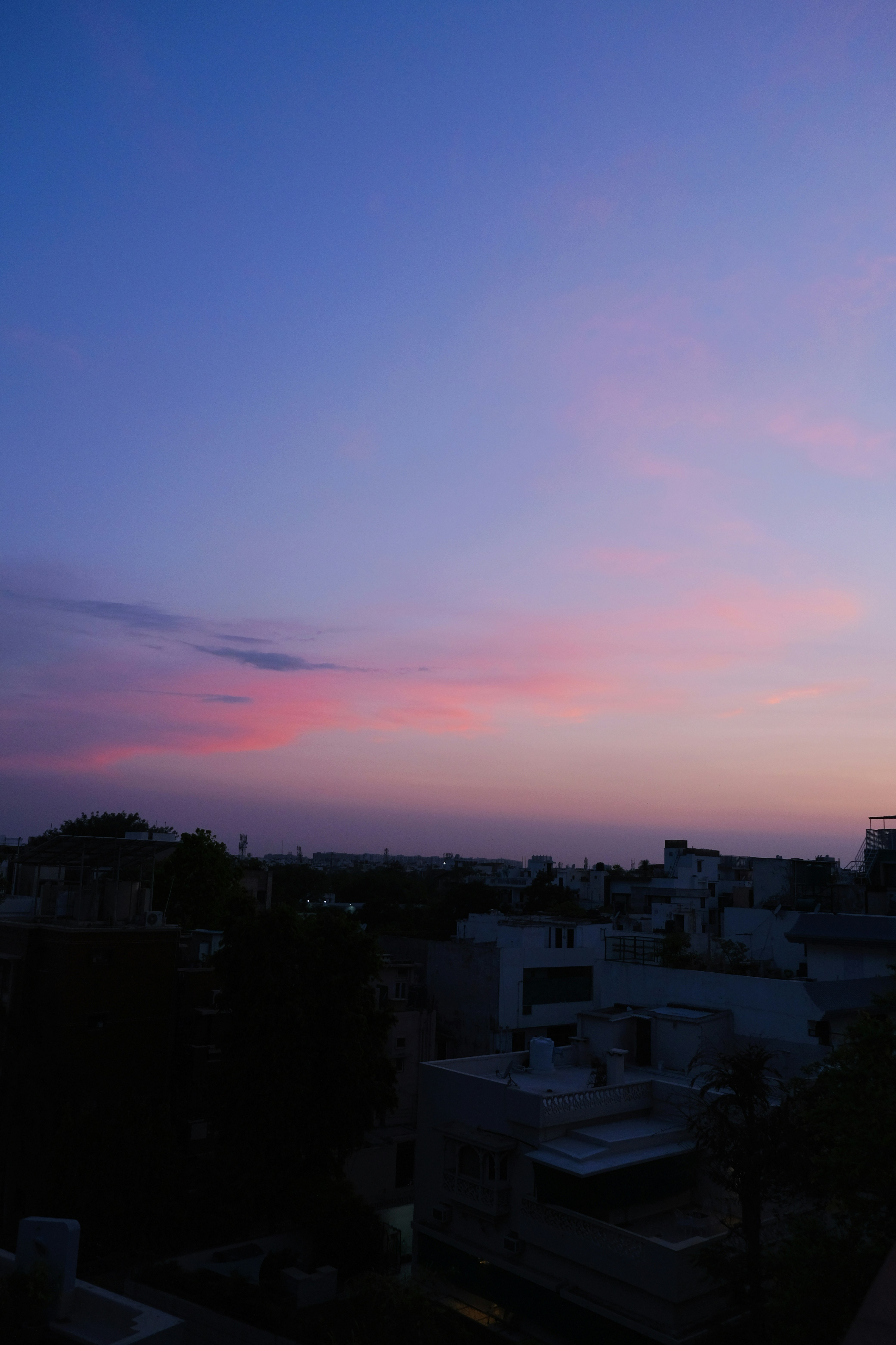 city with high rise buildings under orange and blue sky