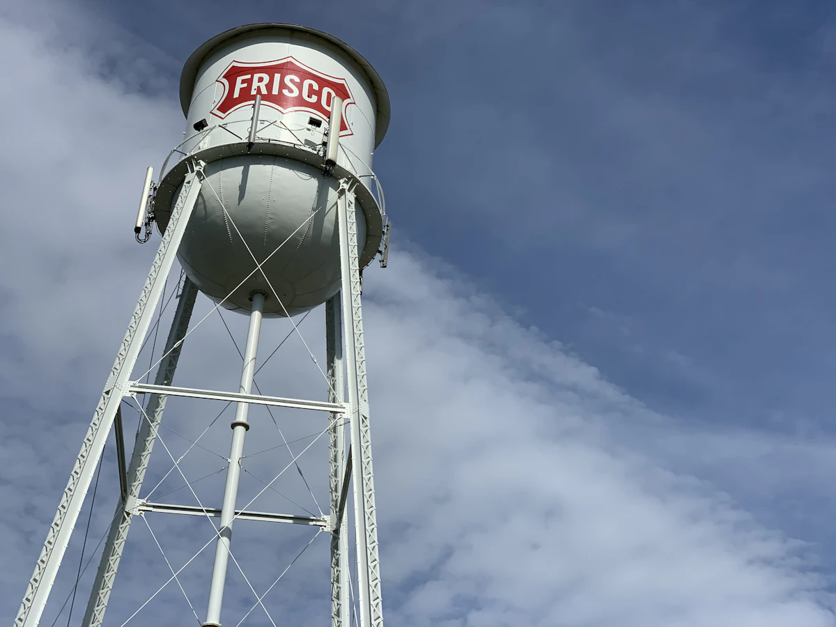 Frisco's white water tower against a blue sky