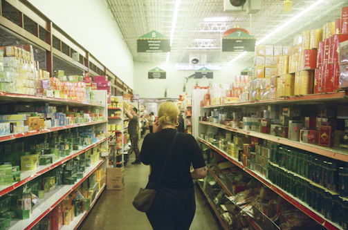 woman in black long sleeve shirt standing near white shelf