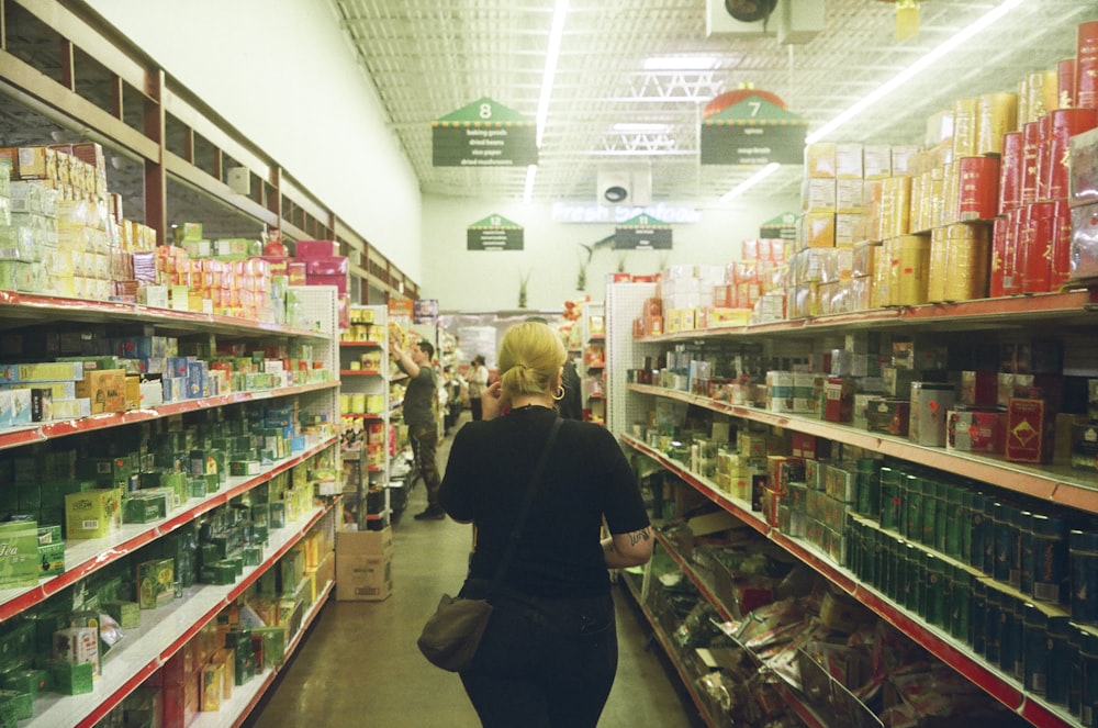 woman in black long sleeve shirt standing near white shelf