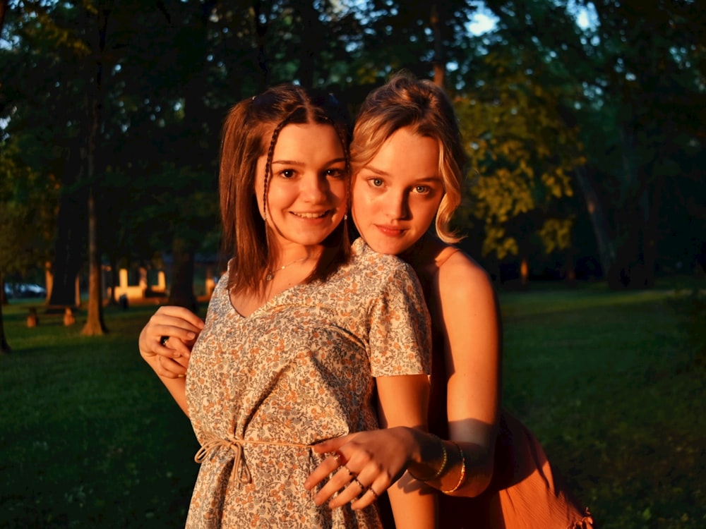 2 women standing on green grass field during daytime