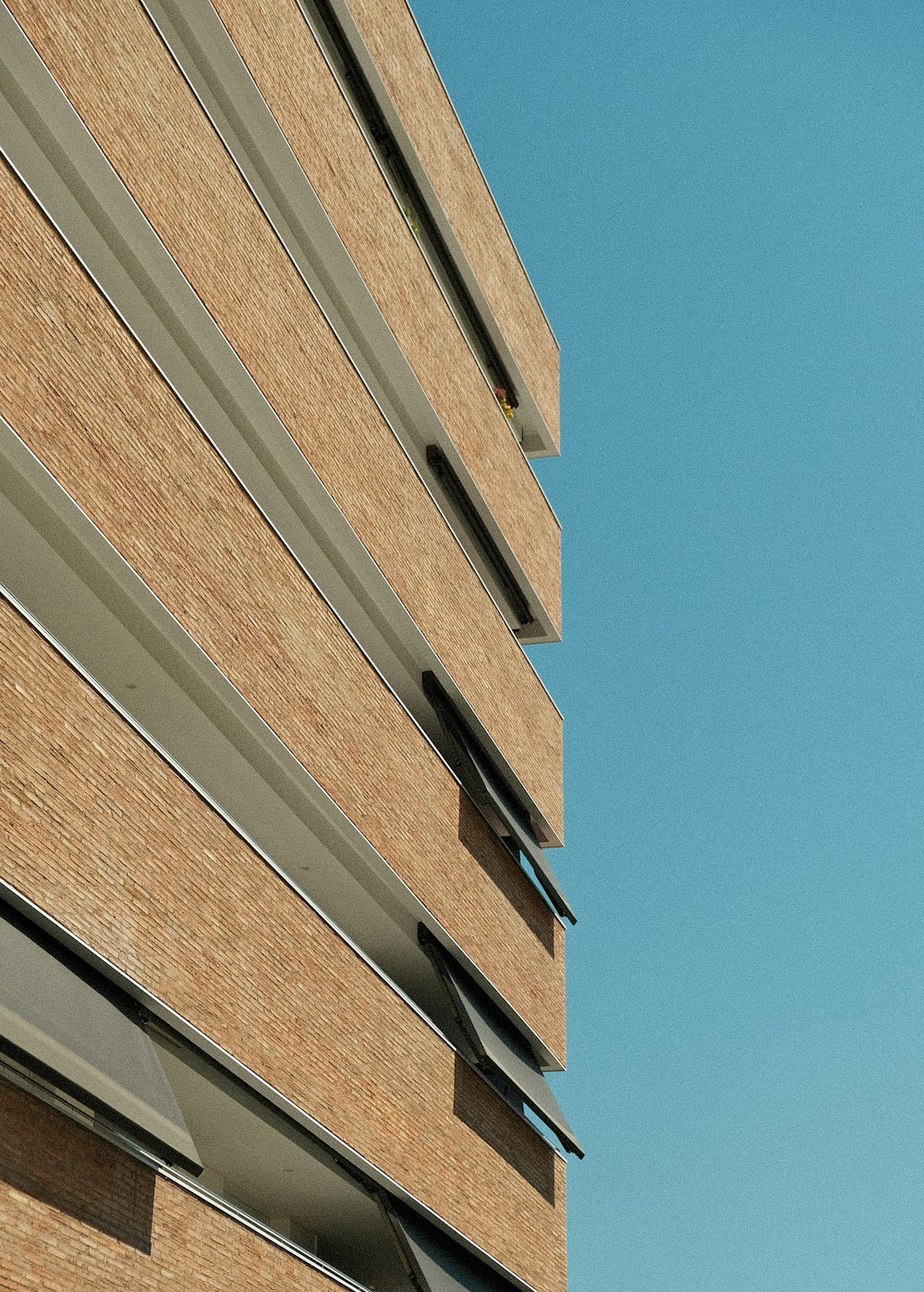 Bâtiment en béton brun sous le ciel bleu pendant la journée