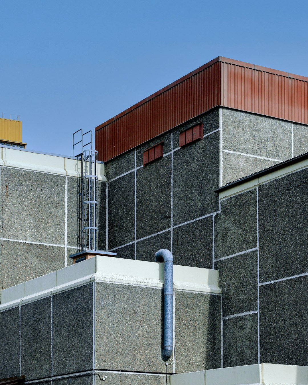 gray and red concrete building under blue sky during daytime