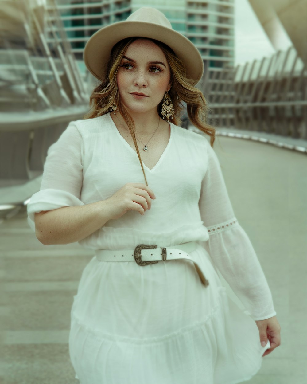 woman in white long sleeve shirt and white skirt wearing brown hat