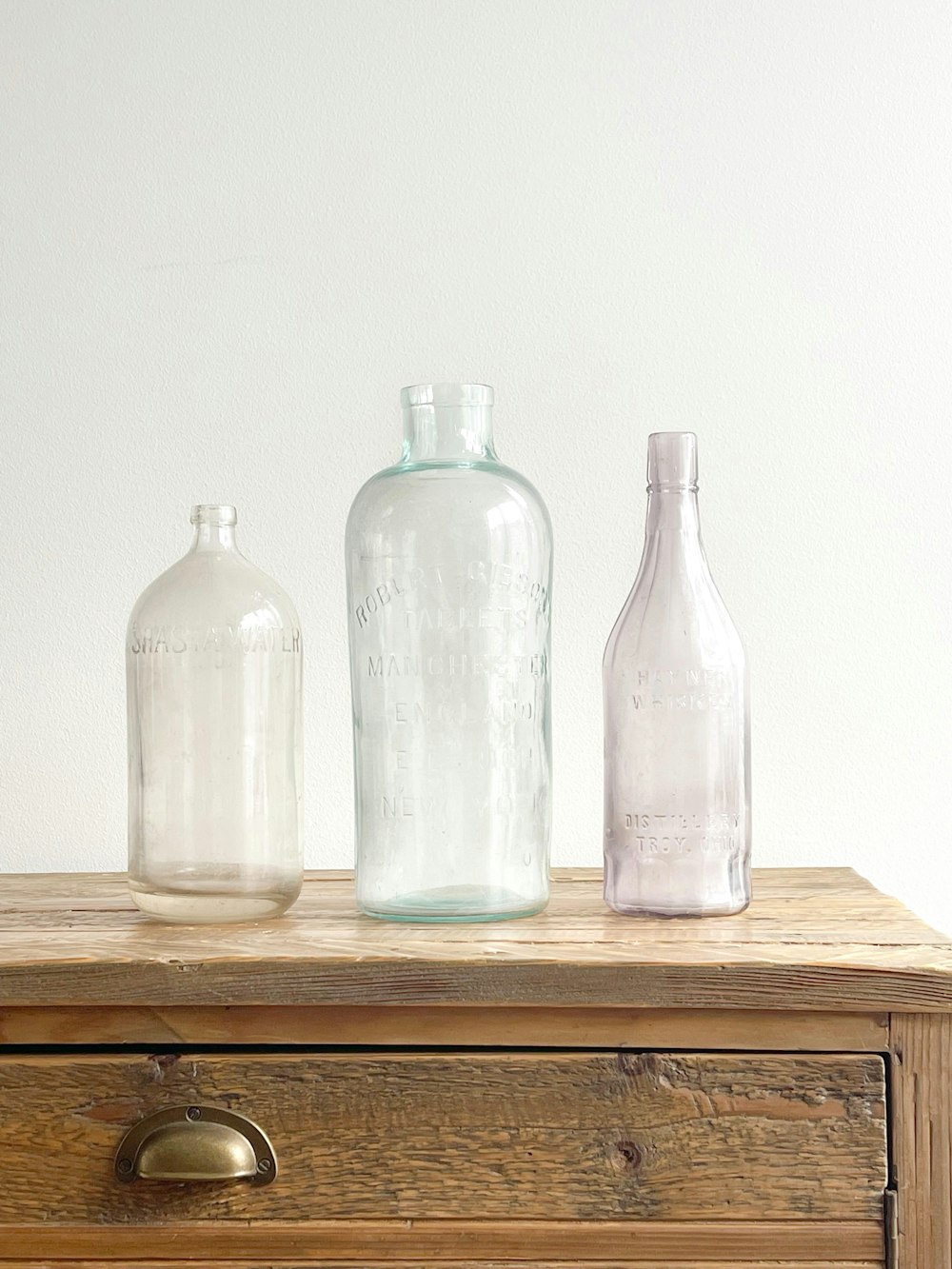 six clear glass bottles on brown wooden table