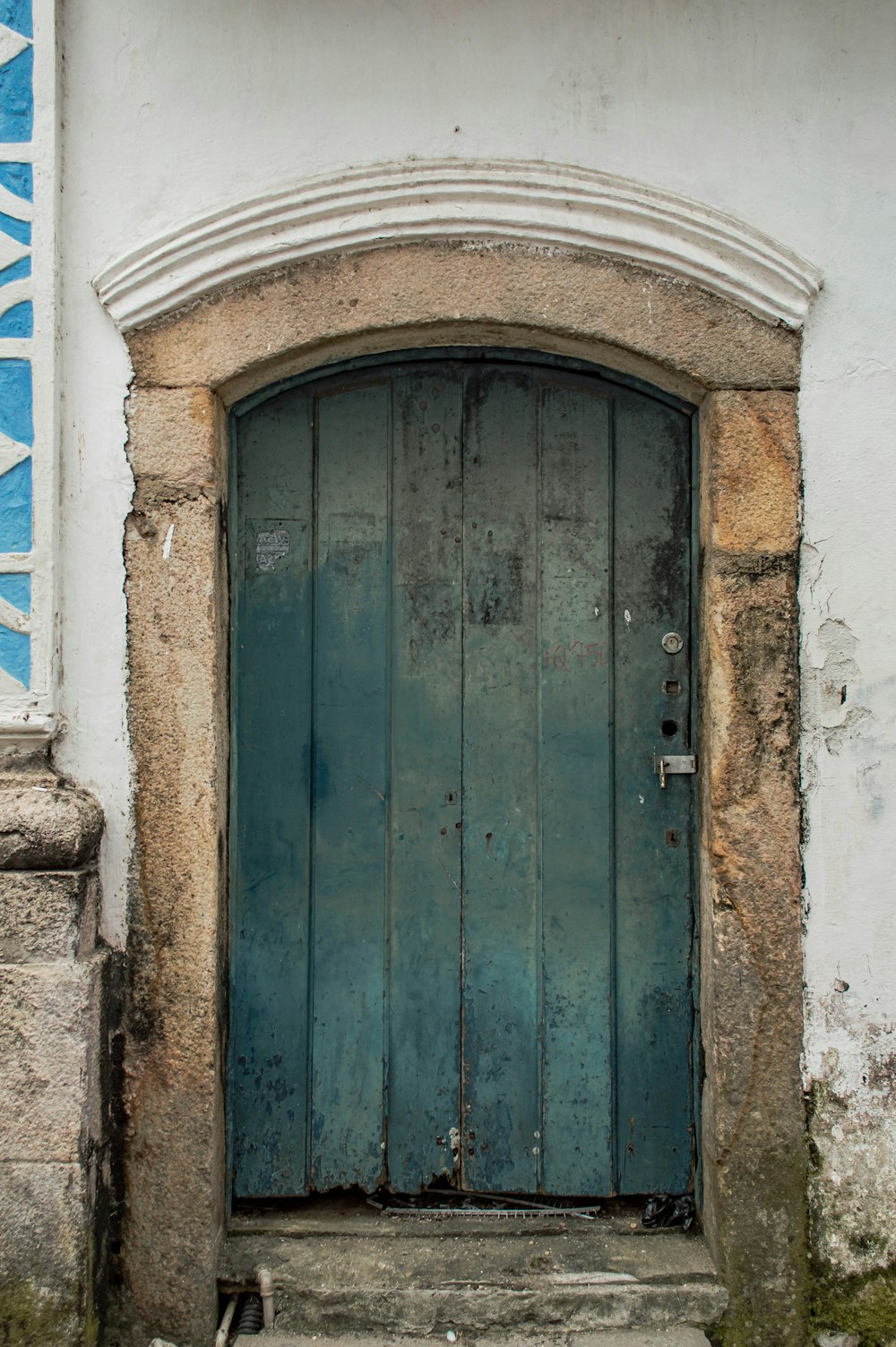 Porte en bois bleu sur mur en béton blanc