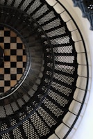 man in black jacket standing on spiral staircase