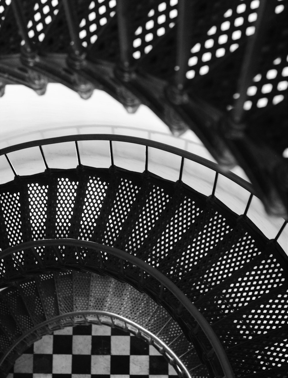 그레이스케일 사진의 검은색 금속 나선형 계단