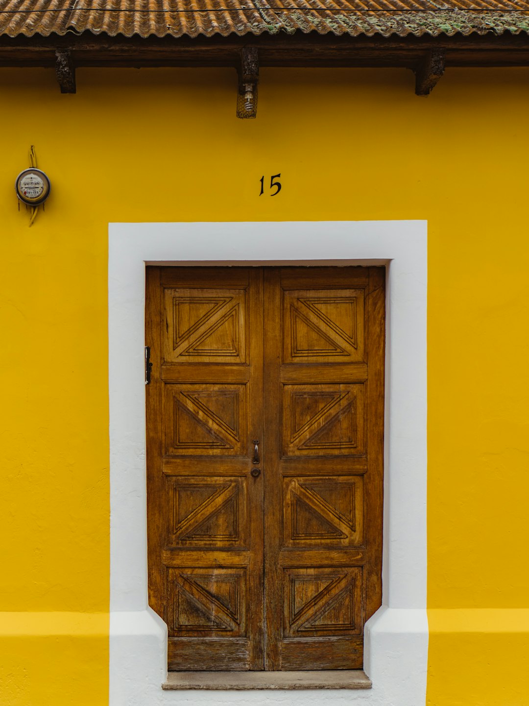 brown wooden door on yellow painted wall