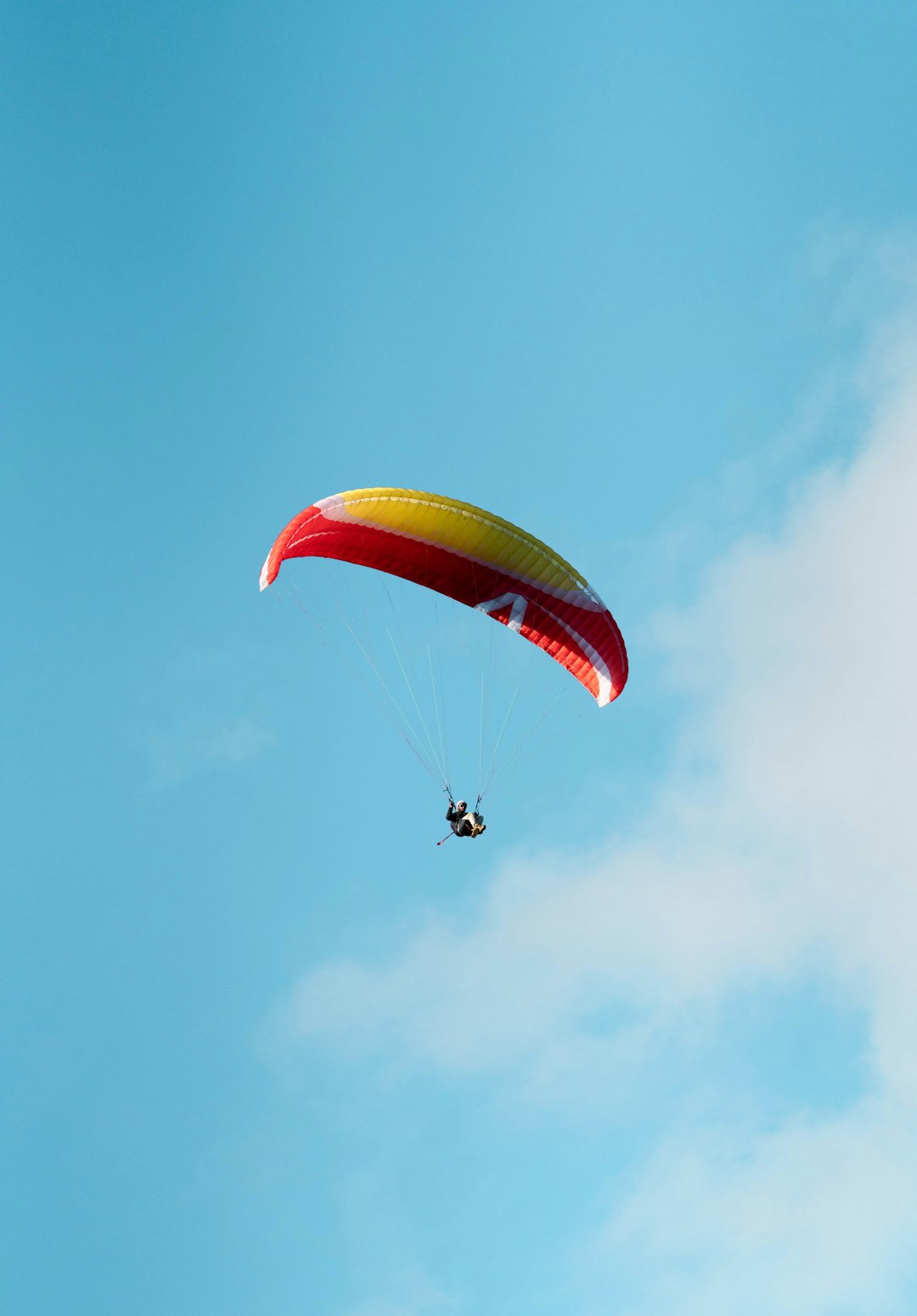 person in red and yellow parachute