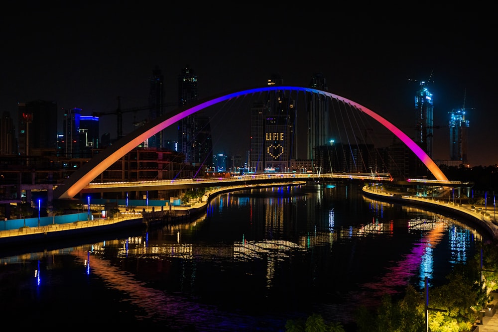 lighted bridge over body of water during nighttime