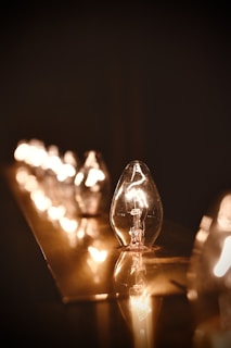 Close-up of sleek LED bulbs glowing warmly on a wooden shelf.