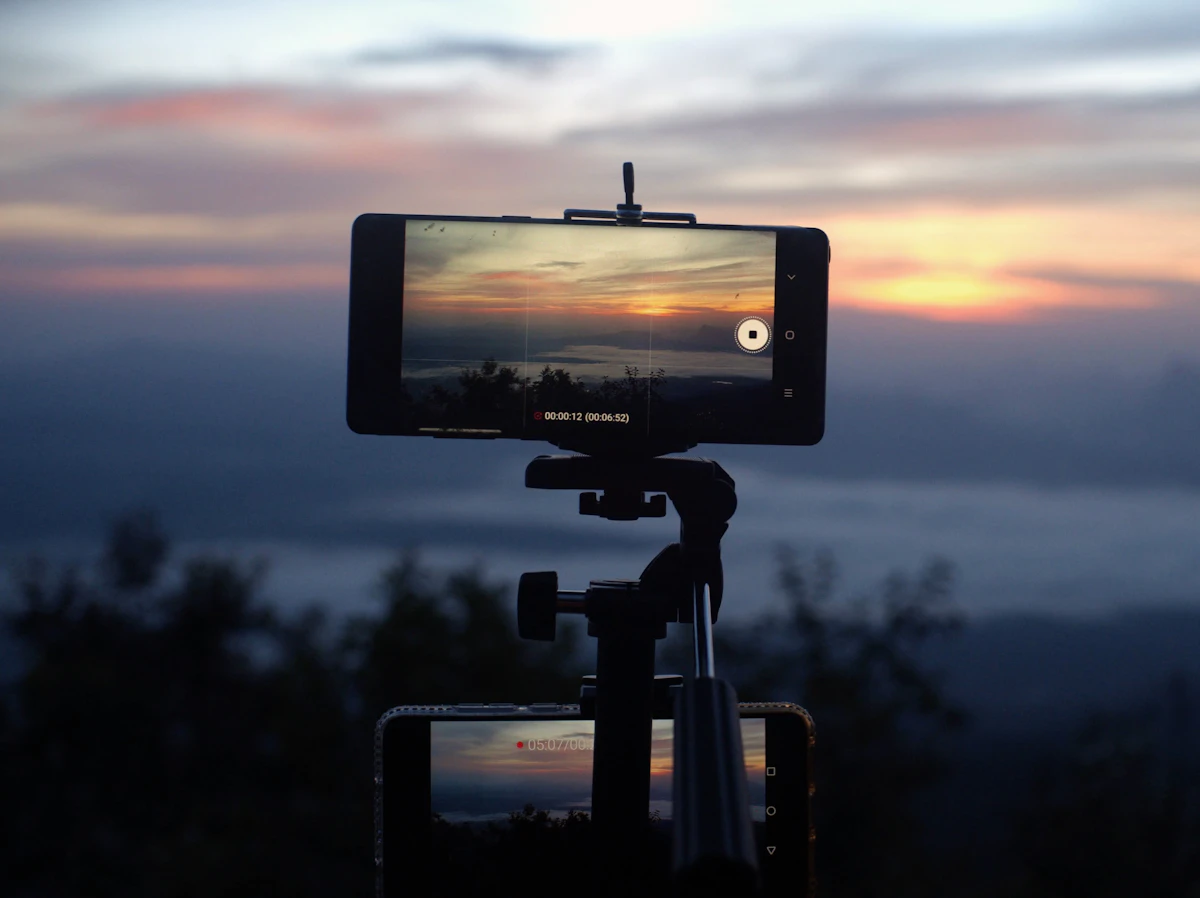 A smartphone recording a sunset over water
