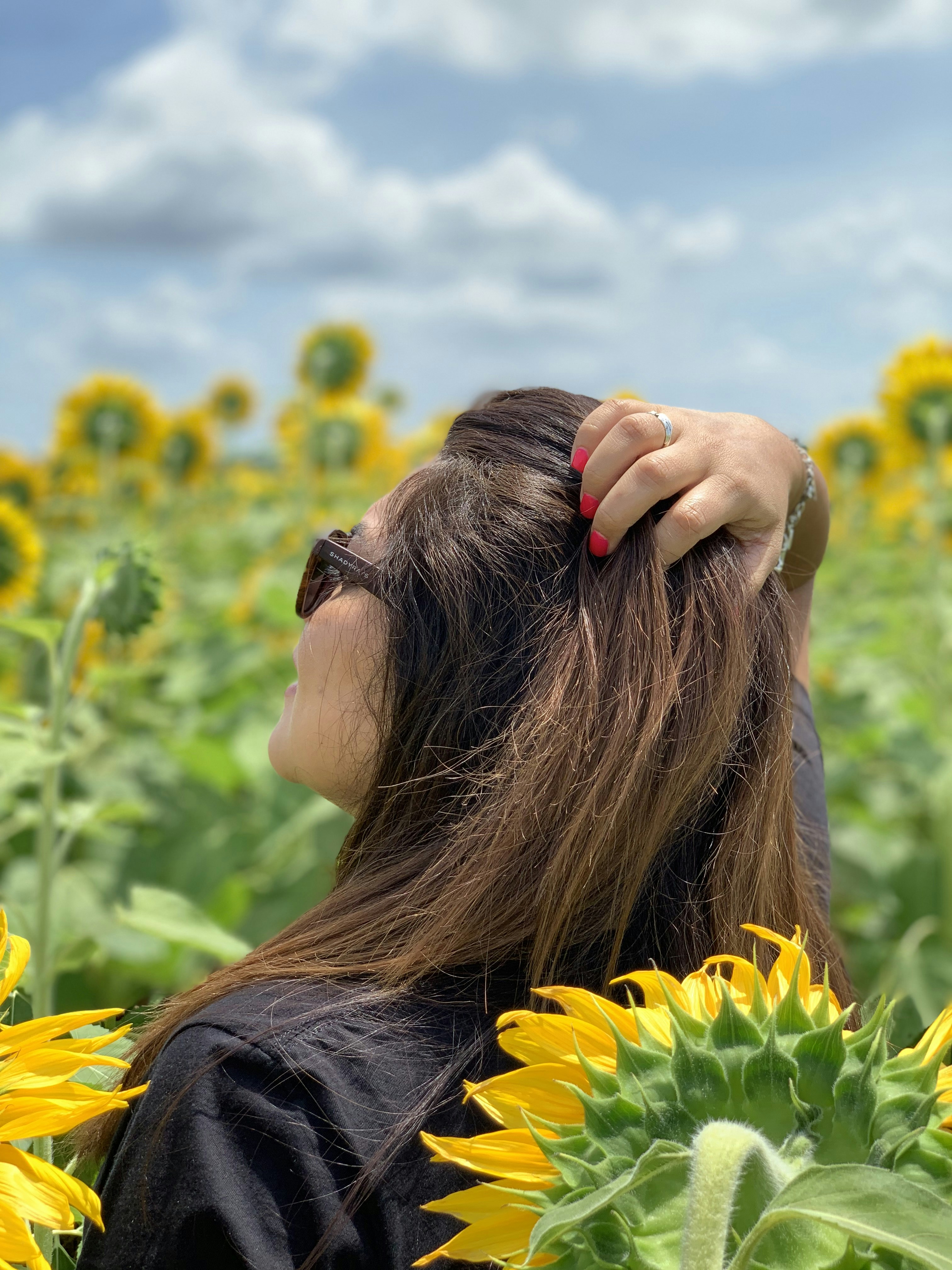 昼間の黄色い花畑で髪で顔を覆っている黒いシャツを着た女性の写真 Unsplashで見つけるヒルズボロの無料写真