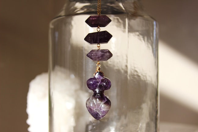 Minimalist display of polished amethyst stones with subtle shadows on a smooth surface.