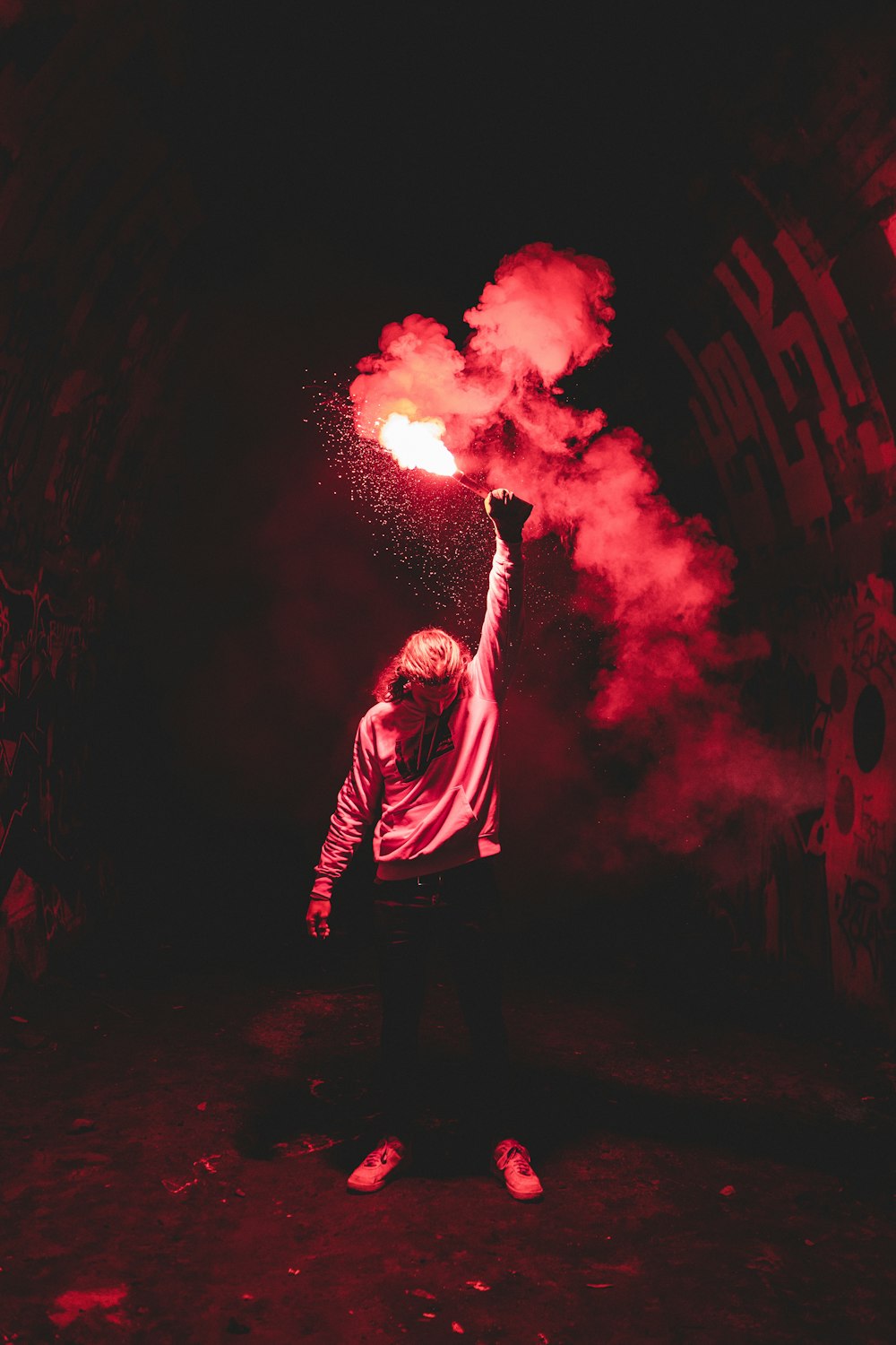 uomo in camicia rossa a maniche lunghe che tiene il fuoco rosso e giallo