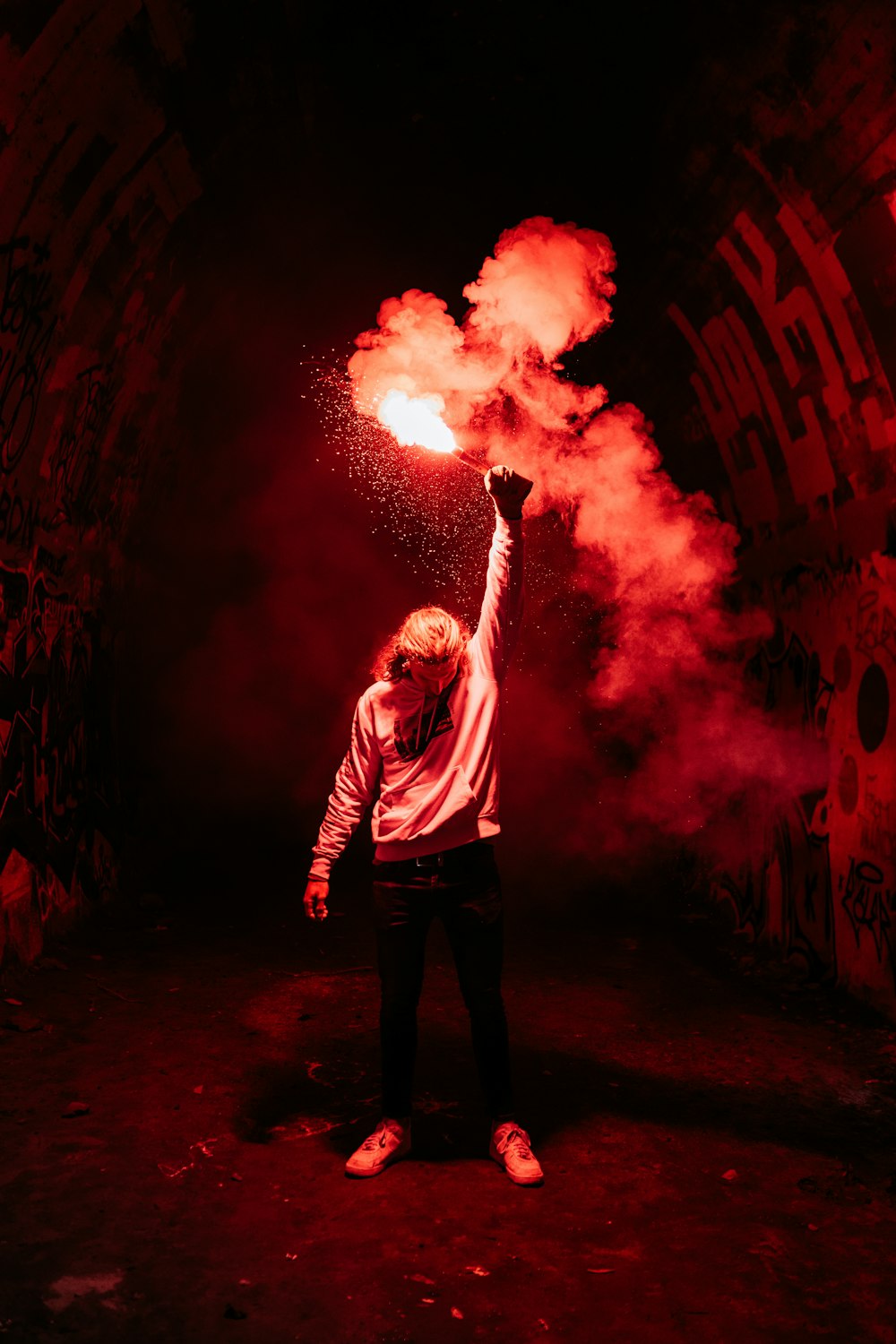 man in gray long sleeve shirt standing in front of red and yellow fire