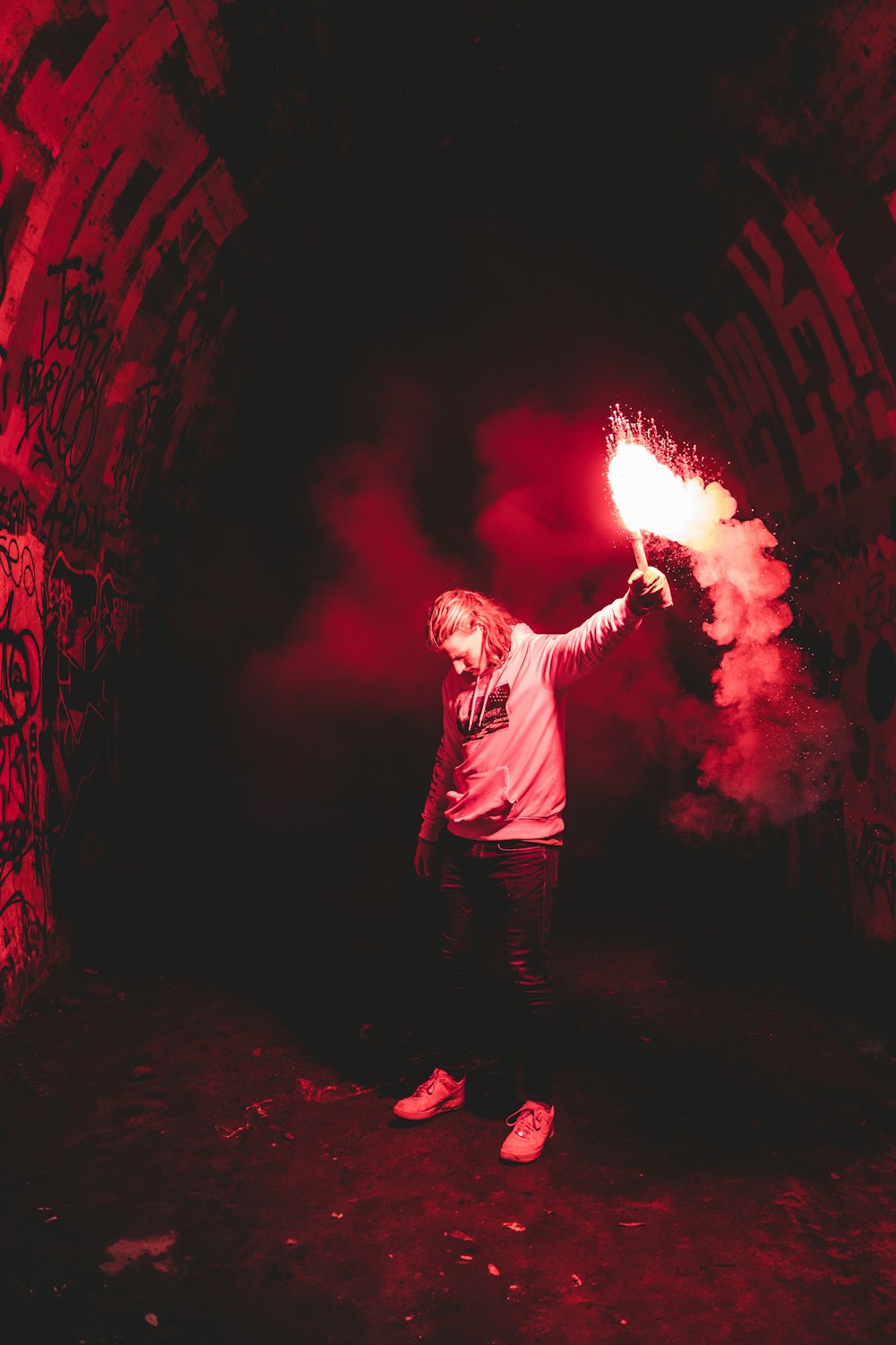 man in black long sleeve shirt and black pants holding fire