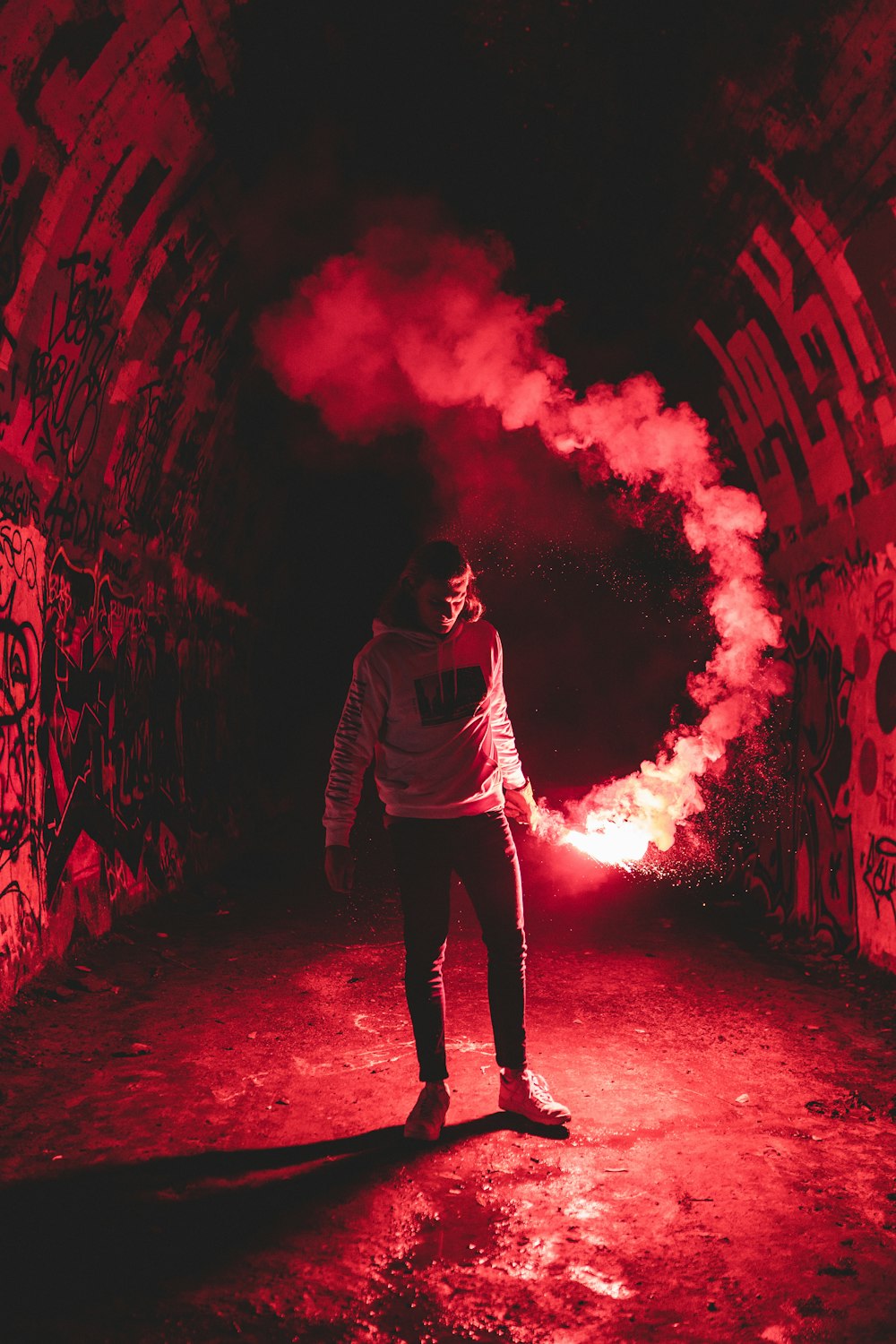 man in gray hoodie standing on red light