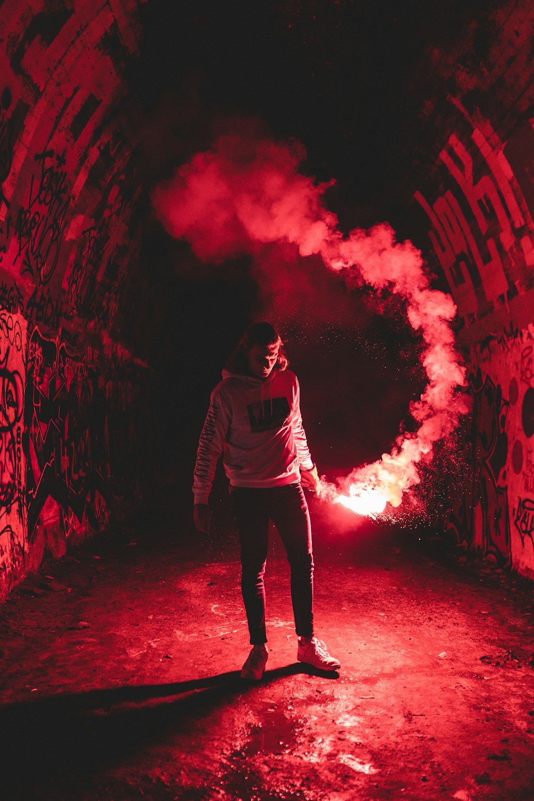 man in gray hoodie standing on red light